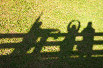 Silhouette of happy family raising their arms to sunshine on the