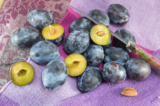 Bunch of fresh plums on a purple background