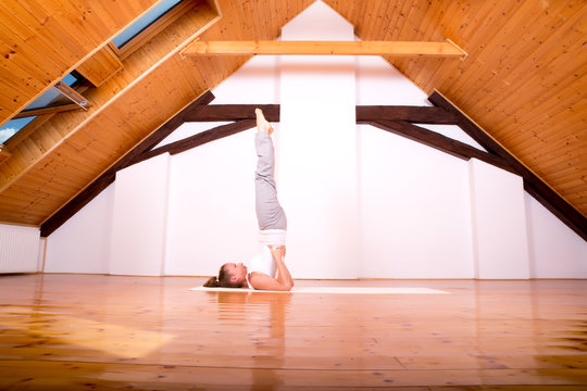 Woman practicing Yoga in a Studio.