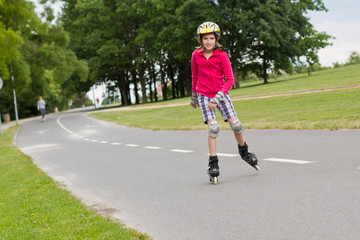 Little girl roller skating in a park