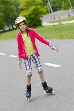 Little girl roller skating in a park