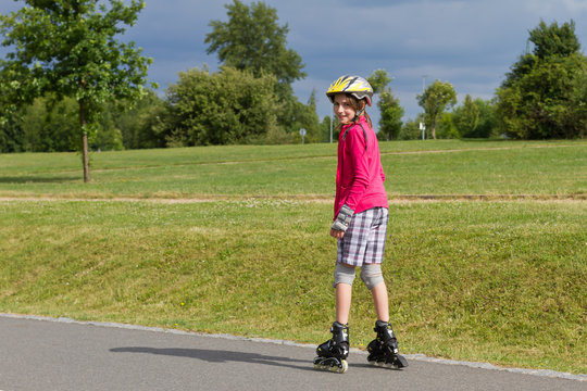 Little girl roller skating in a park