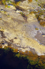River with dirty polluted water and colorful sand during drought