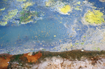 river with dirty polluted water and colorful sand during drought