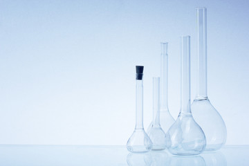 Assorted empty laboratory glassware, test-tubes. Blue tone medical background. Copy space