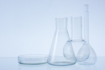 Assorted empty laboratory glassware, test-tubes. Blue tone medical background. Copy space