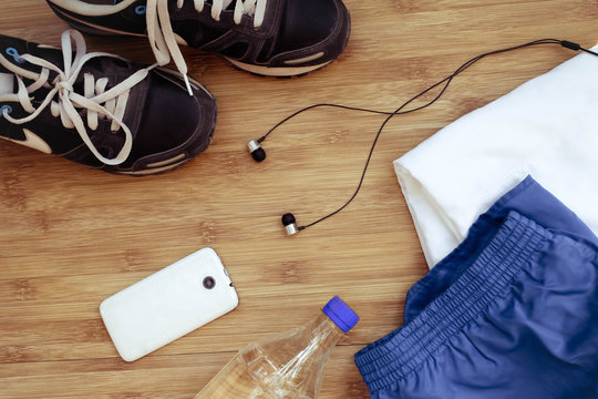 Sport equipment. Sneakers and water on wooden background