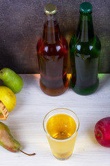 Glass and bottles of cider. Apples and pears