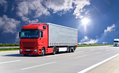 Fototapeta na wymiar LKW transportiert Waren auf der Autobahn // truck on highway
