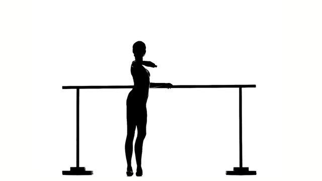 little Ballerina in pointe posing on ballet barre. silhouette