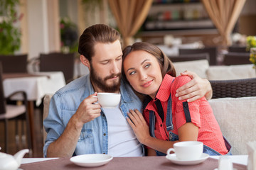 Cheerful man and woman are dating in cafeteria