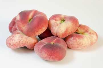 Six whole, medium-size, ripe, juicy saturn peaches shaped like a donut with a sunken middle, white...