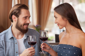Fototapeta na wymiar Cheerful loving couple is enjoying red drink in restaurant