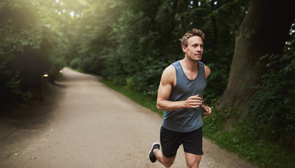 Atletische man doet hardloopoefening in het park