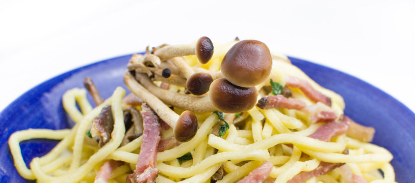 mushrooms on the italian pasta troccoli with smoked ham and rock
