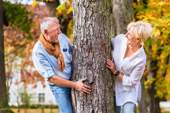 Senioren Mann und Frau flirten an Baum