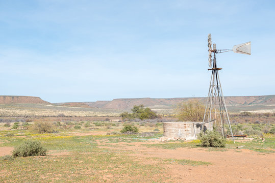 Typical farm scene with water pumping windmill and dam