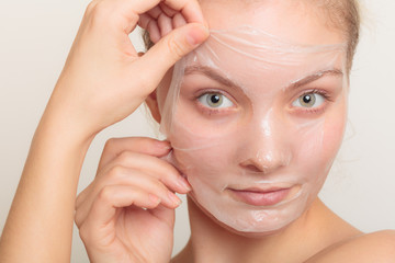 girl removing facial peel off mask