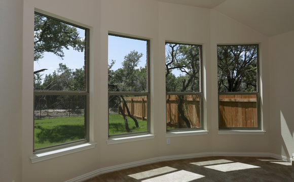Windows of new modern house with view on green backyard and new fence
