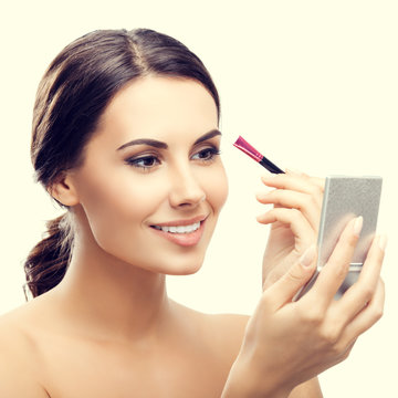 woman with cosmetics brush and mirror