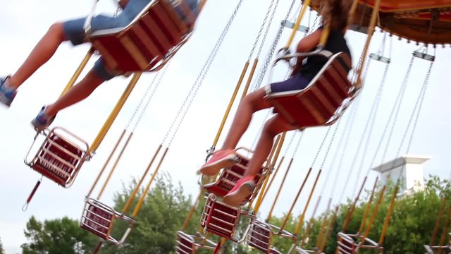 Carousel swings with kids in amusement park 