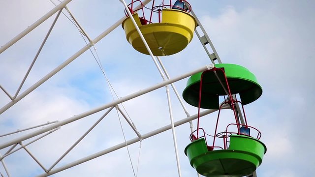 Ferris Wheel with colorful cabins in amusement park 