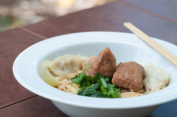 Egg noodle with delicious stewed pork and dumpling, closed up.