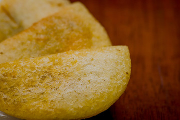 Closeup three perfect empanadas on white plate with wooden