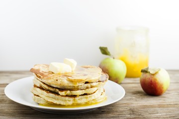 pancakes with apple and honey on wooden table