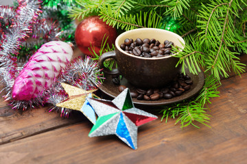 Branch of green fir tree with christmas toys and cup of coffee