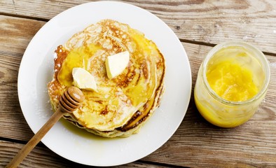 pancakes with apple and honey on wooden table