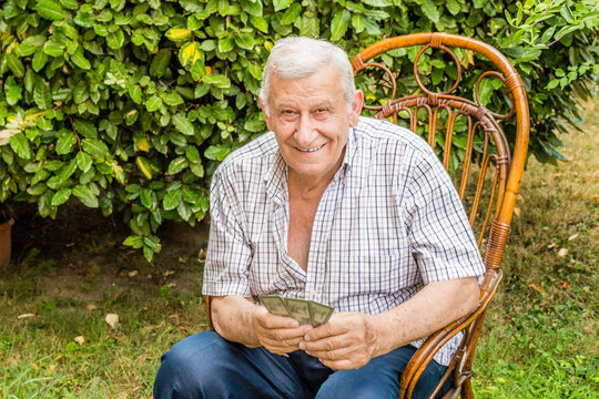octogenarian elder play cards in the garden