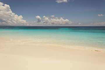 blue sky with sea and beach - soft focus with film filter