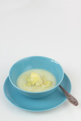 Blue bowl of cauliflower and potatoes soup.