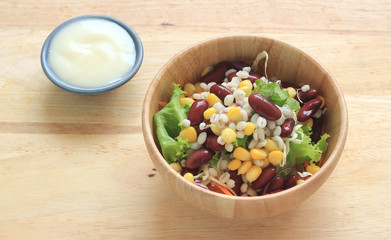 Healthy salad with fresh vegetables on wood background