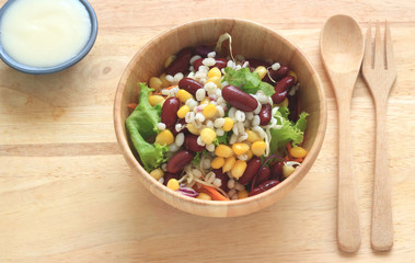 Healthy salad with fresh vegetables on wood background