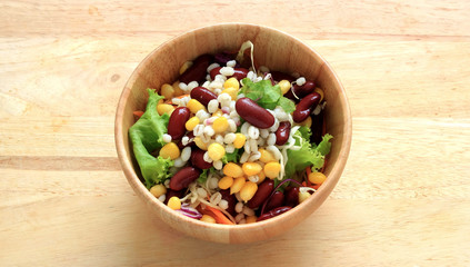 Healthy salad with fresh vegetables on wood background