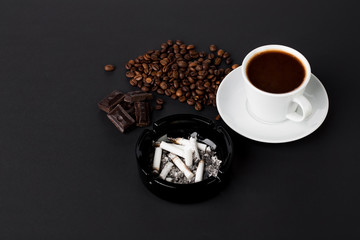 Cup of coffee with ashtray and beans chocolate