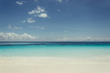 Obraz na płótnie Canvas blue sky with sea and beach - soft focus with film filter