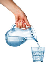 Hand pouring water from glass pitcher