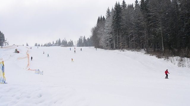 People ski downhill on a slope in Bukovel, Carpathians, Ukraine