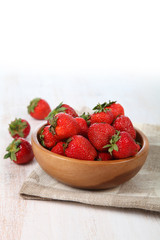 Ripe strawberry in a wooden bowl