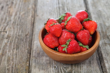 Ripe strawberry in a wooden bowl