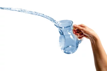 Fotobehang Hand pouring water from glass jug © verdateo