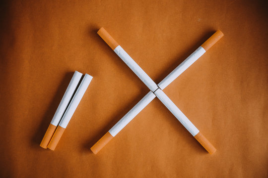 Some cigarettes with filter on brown background