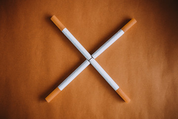Some cigarettes with filter on brown background