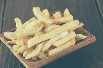 french fries on wood background - soft focus with vintage film f