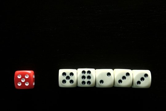 One Red game dice and five white game dice