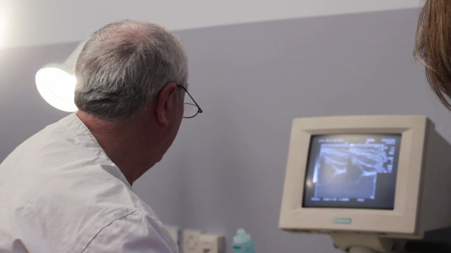 Control of newborn babies. The doctor examining newborn hips. Doctor close up.