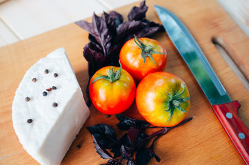 closeuo of tomatoes, basill, cheese, knife